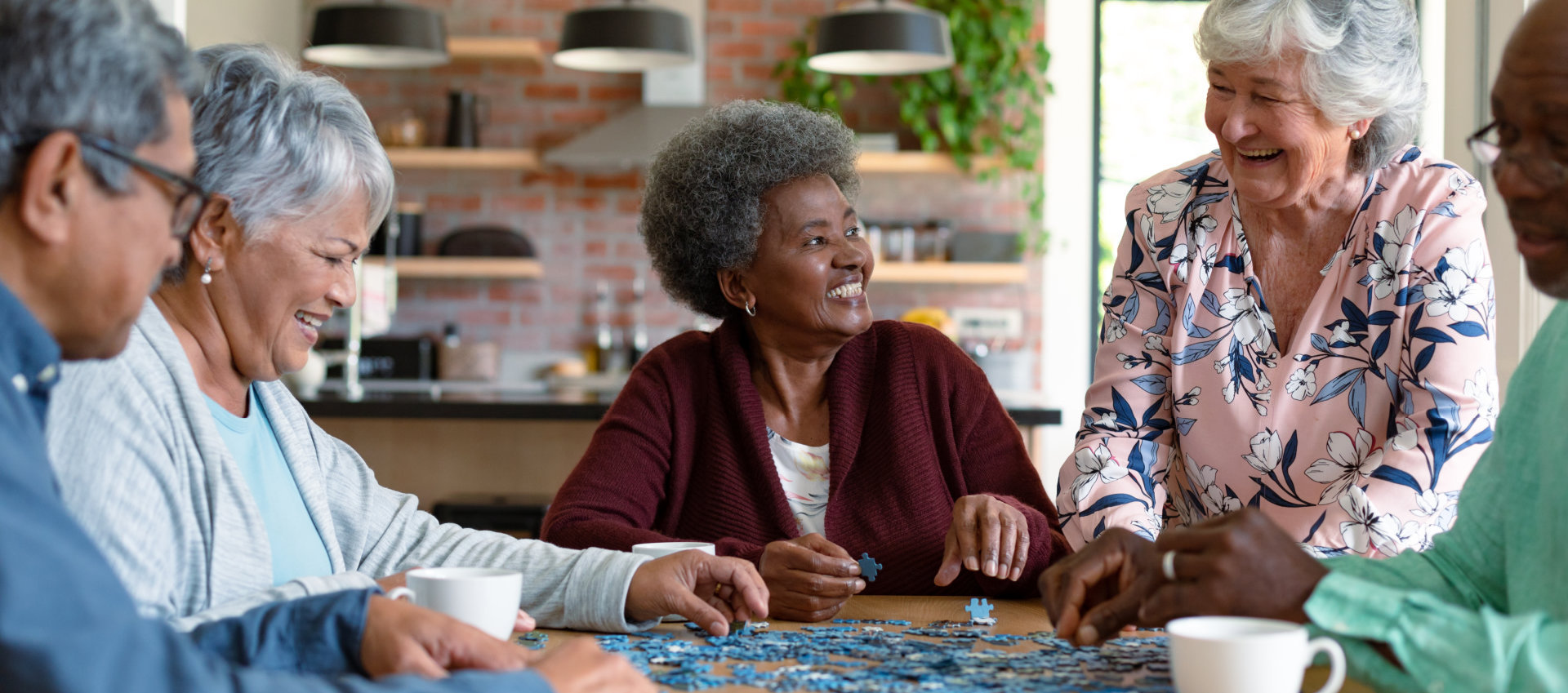 group of elderly smiling while playing puzzle