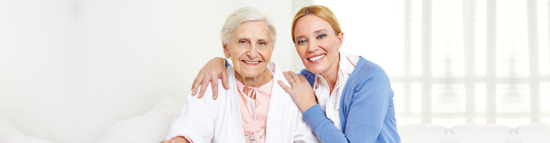 female aide and elderly woman smiling