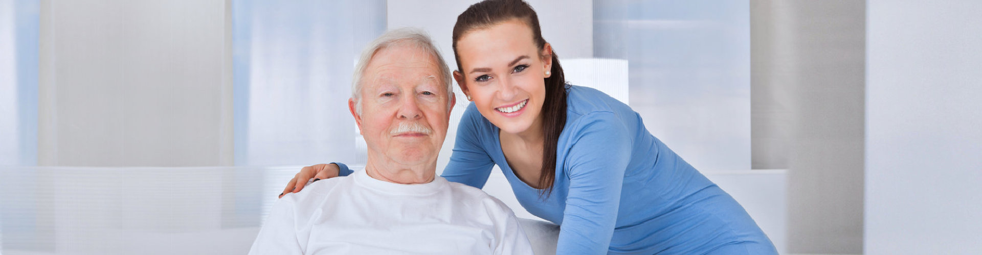female aide and elderly man smiling
